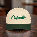 Beige cap with green 'Cafecito' text on a wooden surface