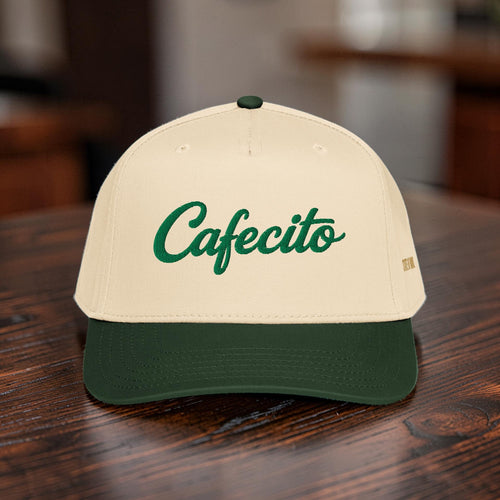 Beige cap with green 'Cafecito' text on a wooden surface