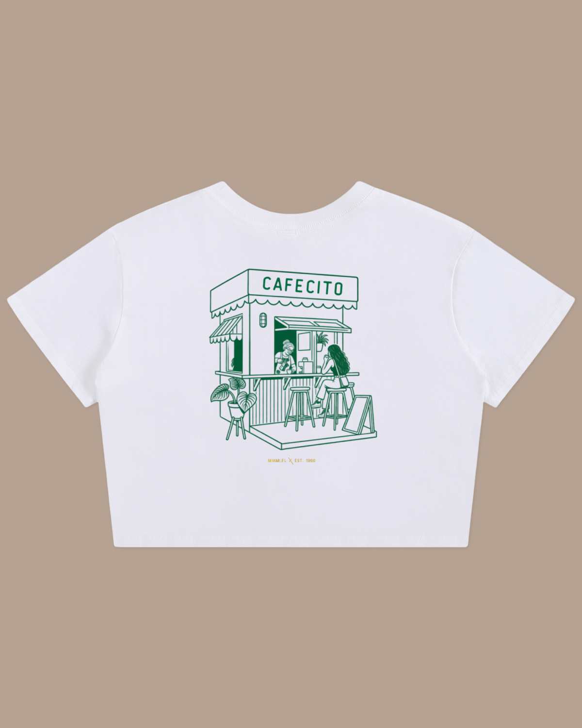 A womens white short-sleeve crop top featuring a green line art graphic of a cafe storefront labeled 'CAFECITO' with small text below reading Miami Est. 1960